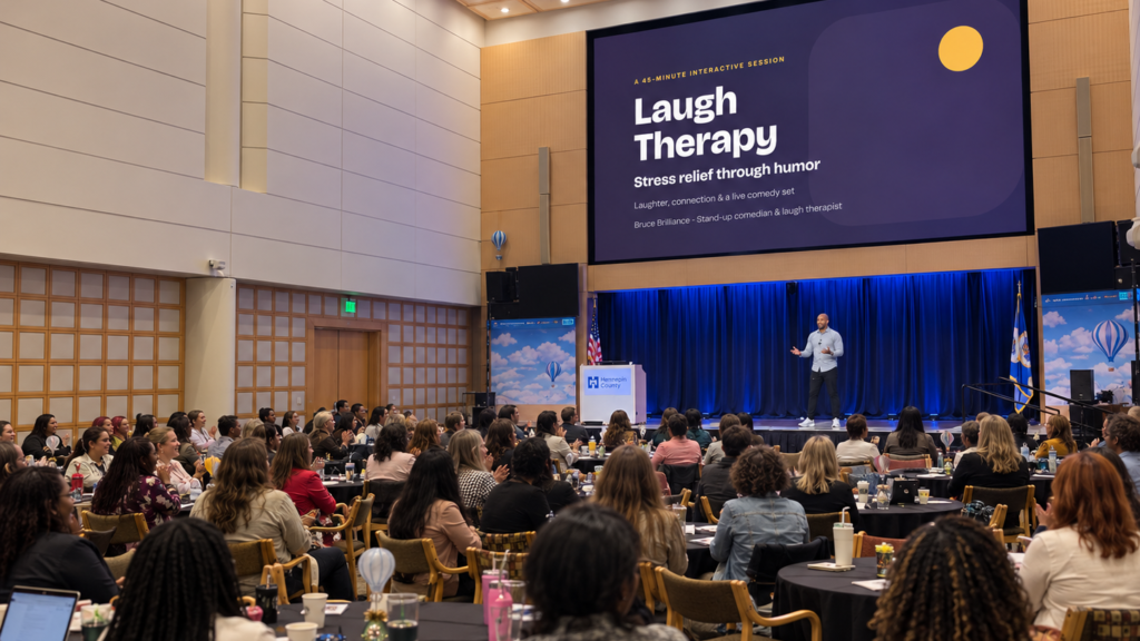 Bruce Brilliance on stage presenting Laugh Therapy: stress relief through humor at Hennepin County’s Still We Rise conference