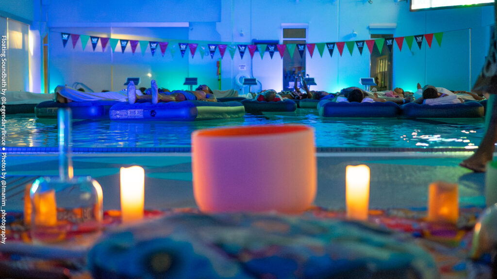 Candles and a crystal singing bowl beside the pool at Floating Soundbath MPLS