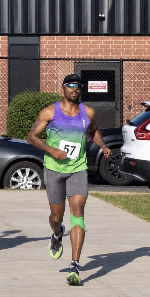 Bruce Leroy Williams running the 5K leg of the Push Triathlon in bib 57