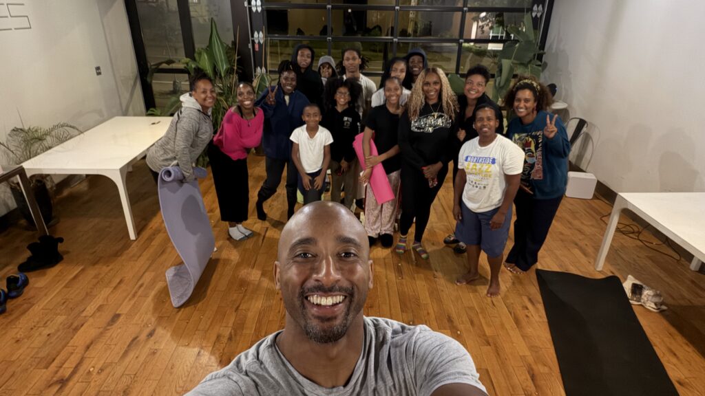 Bruce Leroy Williams taking a group selfie with the Northside Free Yoga community at New Rules