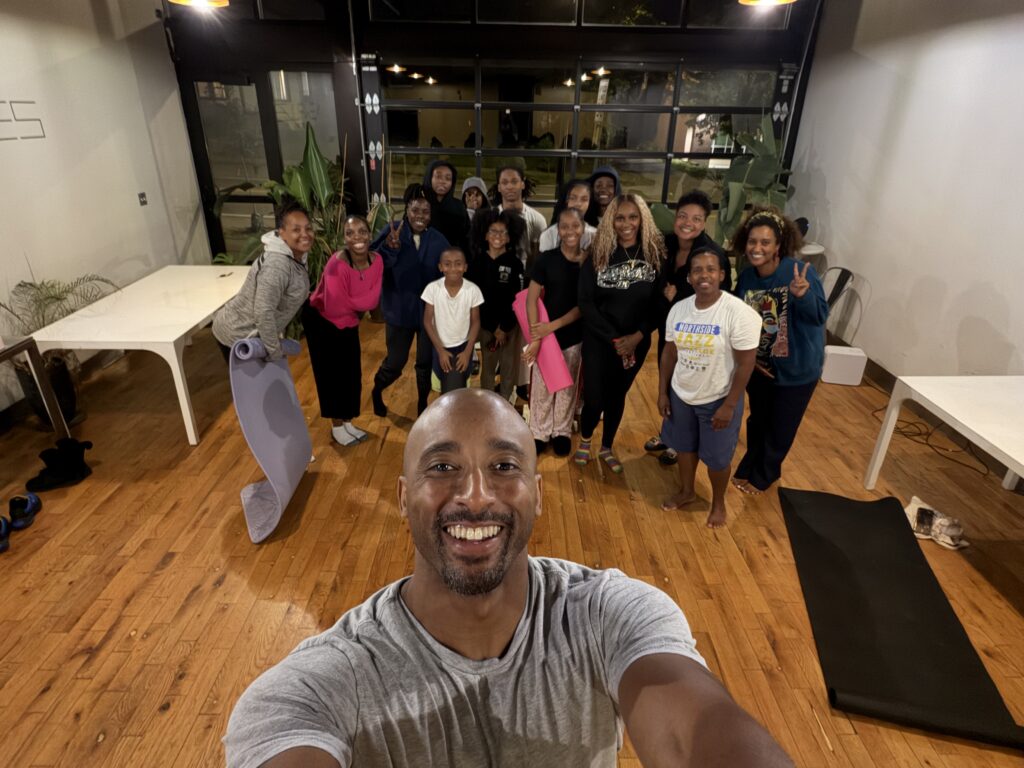 Bruce Leroy Williams taking a group selfie with the Northside Free Yoga community at New Rules