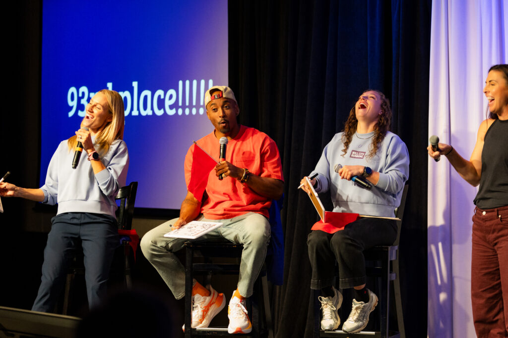 Bruce Brilliance holding a microphone among the contestants during the Twin Cities Game Show